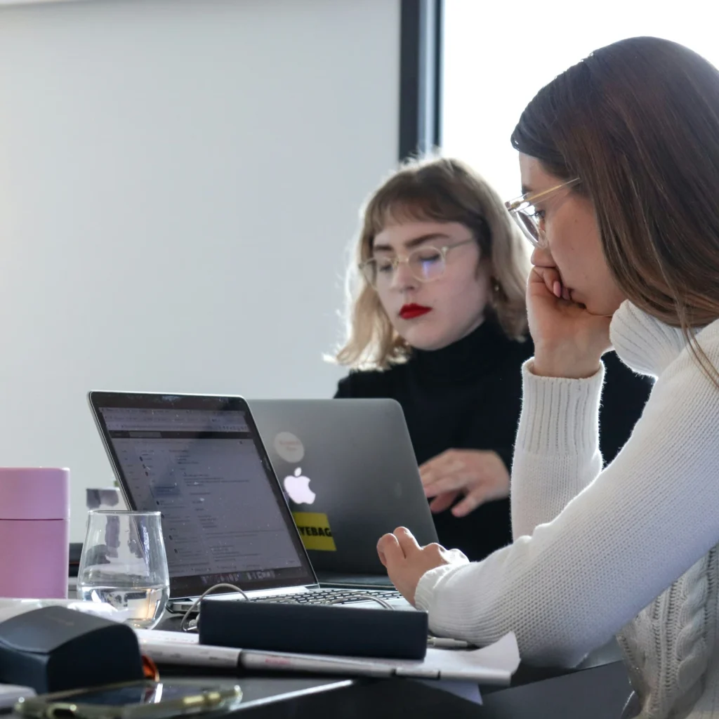 Image de deux femmes qui travaille sur l'analyse de données pour travailler la stratégie marketing d'un client de MD Consulting.